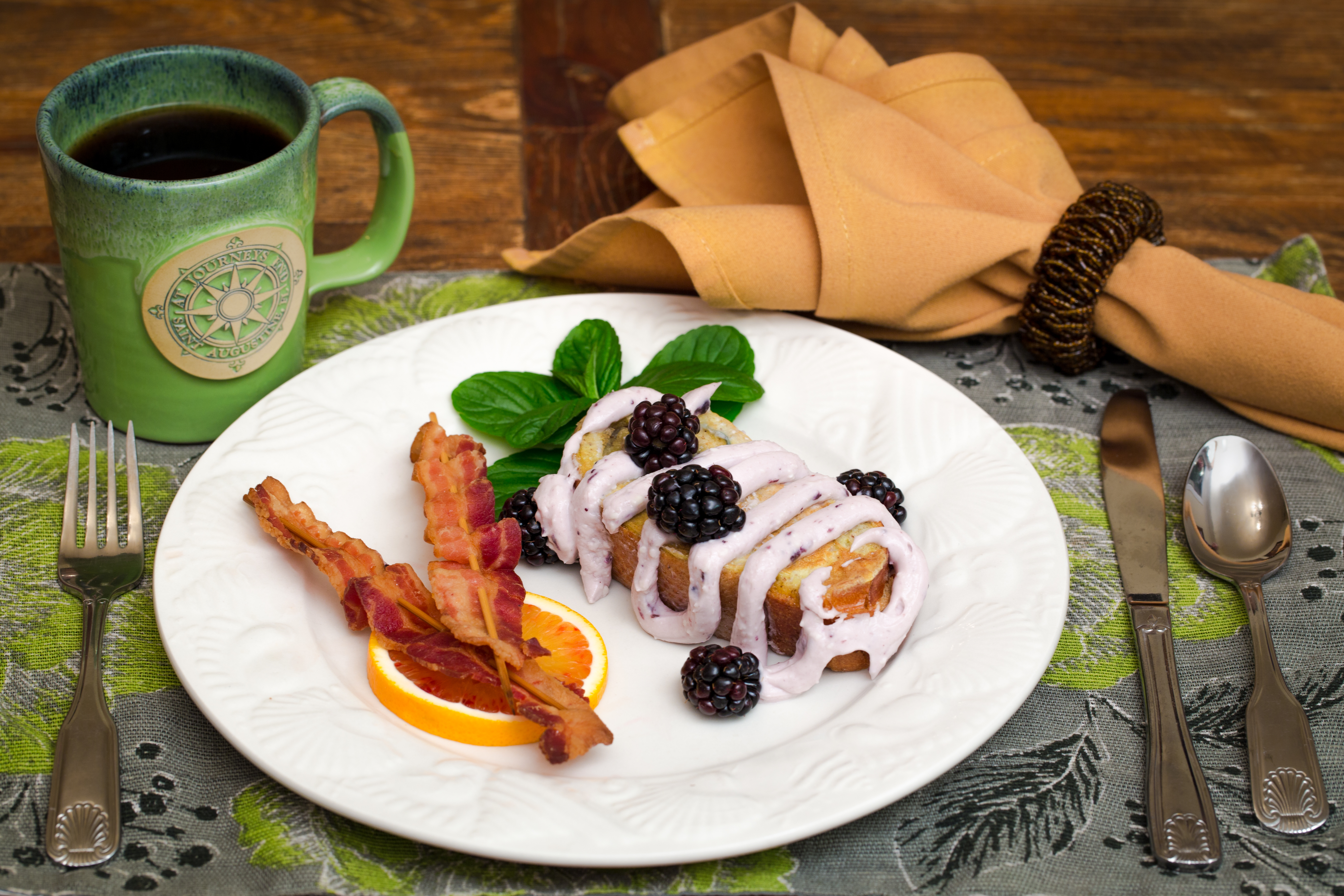 Photo of Breakfast plate showing French Toast with Blueberry Cr Cheese Drizzle and Bacon